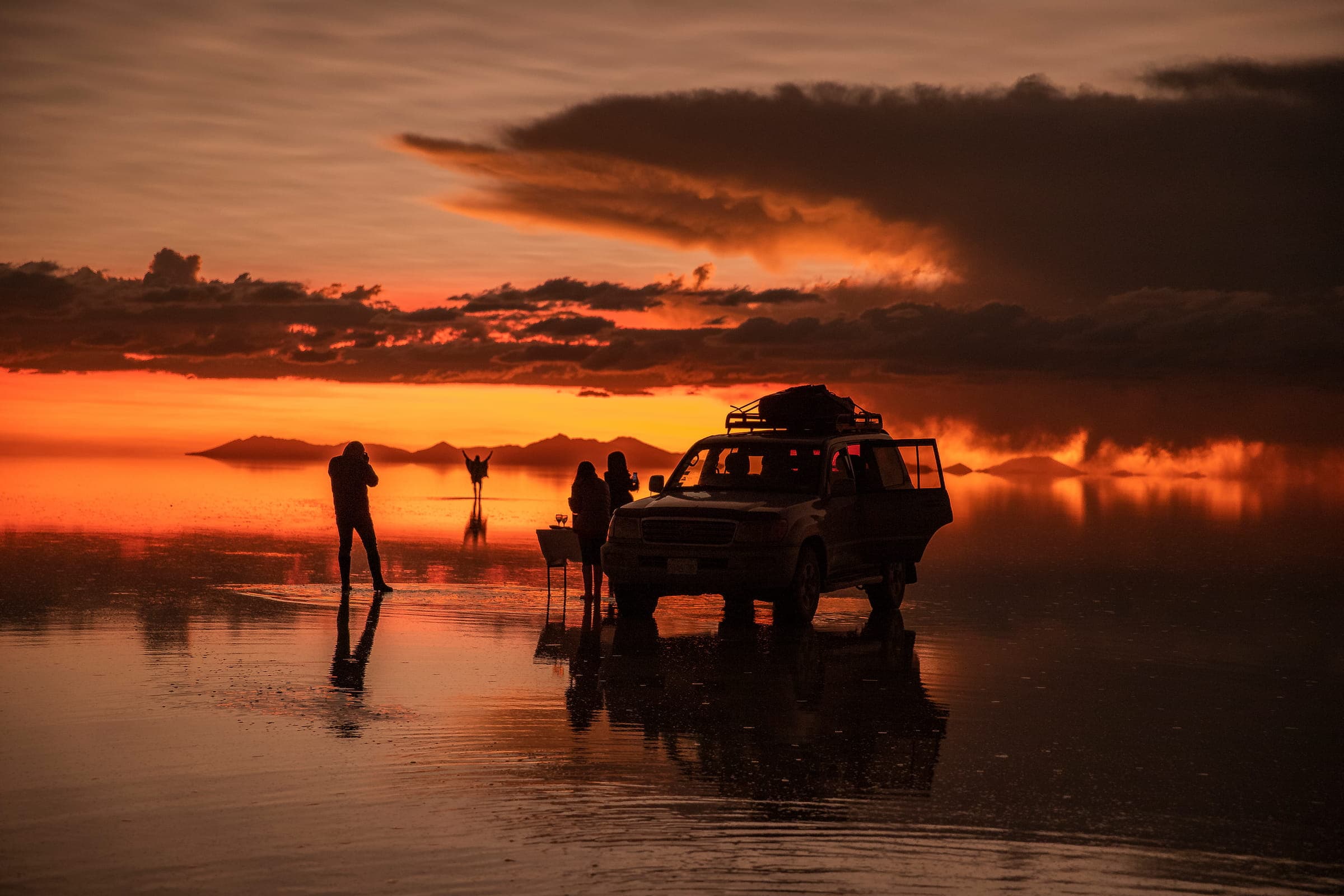 Salar de Uyuni con colores rojos y naranjas al atardecer, Bolivia